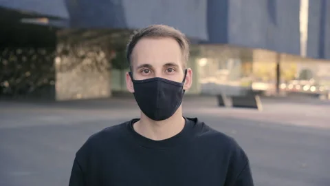 Looking to the camera. Portrait of a young Hispanic man with a face mask due  Stock Footage 143615605