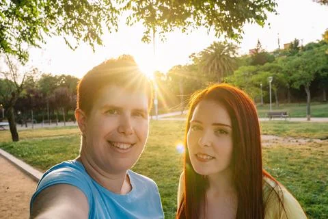 Looking at the camera two great friends taking a selfie, in a public park in the Stock Photos