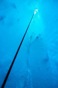 Looking up a climbing rope from deep inside an ice cave in the Salmon Glacier Stock Photos