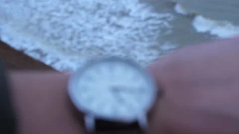 Looking on the clocks on a mans hand with depressive sea waves on background Stock Footage 151654862