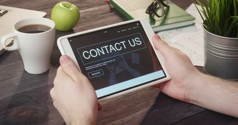 Looking at contact us web page using digital tablet at desk Video stock 80734258