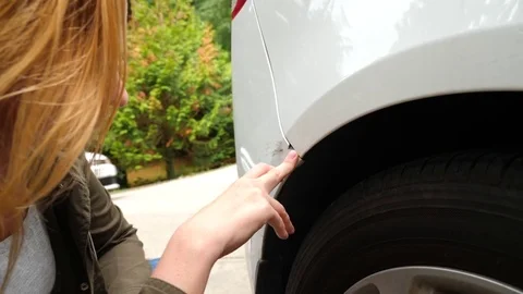 Looking at a damaged vehicle. Woman blonde inspects car damage after an accident Stock Footage