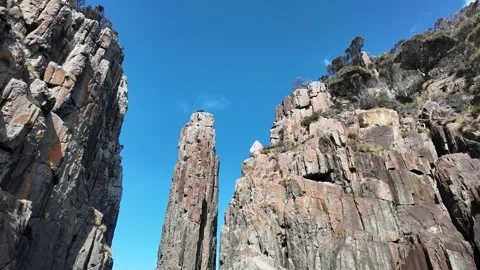 Looking up at a dolerite sea stack and cliffs from Tasmanian waters Stock Footage 347272777