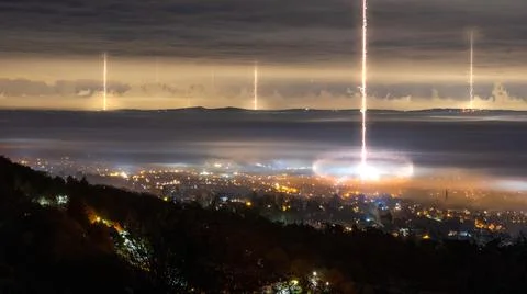 Looking down as alien laser weapons come down from clouds Stock Photos