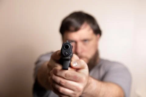 Looking down the barrel of a pistol Stock Photos