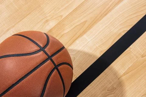 Looking down on a basketball and black line with arena wood floor in the Foto stock