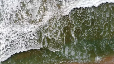 Looking Down At Beach And Waves Coming Onto Sand 4K Aerial Drone Shot 動画素材 107287417