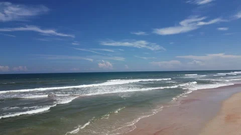 Looking down the beach with blue skies Vídeo Stock 250354430