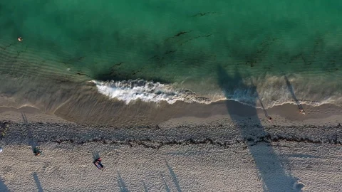 Looking down on a beach full of people and flying left Stock Footage 103344622