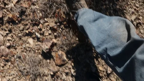 LOOKING DOWN AT BOOTS WALKING THROUGH DESERT LANDSCAPE Stock Footage 96231956