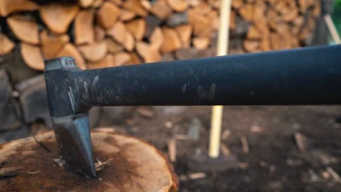Looking Down Chopping Axe Handle in Wood Block by Wood Pile Stock Footage 96034178