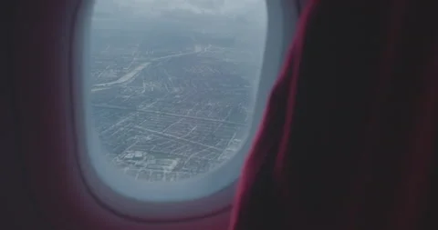 LOOKING DOWN AT CITY FROM PLANE CABIN WINDOW Stock Footage 141477907
