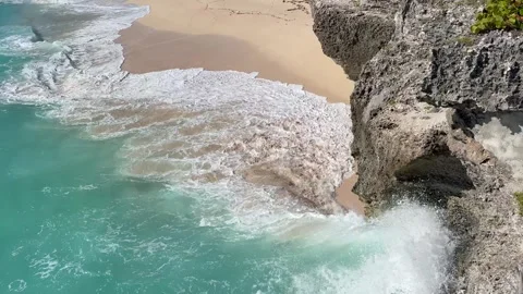 Looking down a cliff to a beach, turquoise waves hitting the beach  Stock Footage 321406814