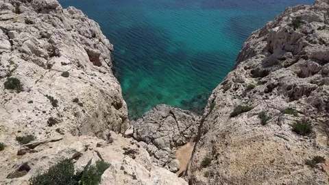Looking down from the cliff at the sea coast. Lonely small motorboat in crystal 스톡 동영상 76988286