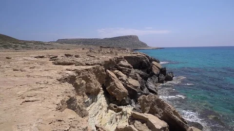 Looking down from the cliff at the sea coast. Lonely small motorboat in crystal Stock-Footage 76988330