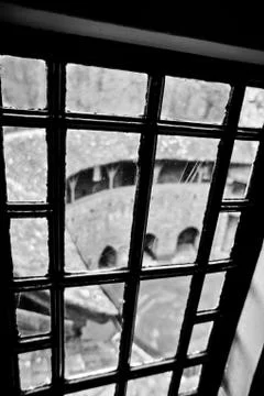 Looking down into a courtyard through an old castle panel window Stock Photos