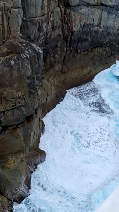 Looking down at crashing ocean waves from metal grate viewing platform Video stock 335654146