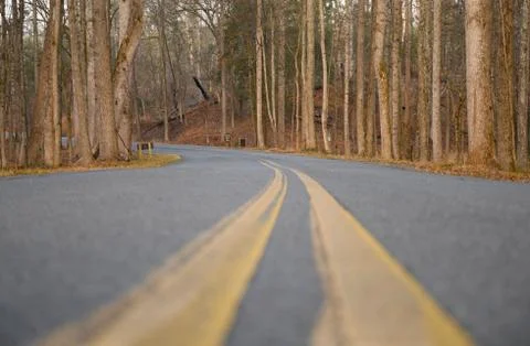 Looking down the double yellow lines on a country road. Stock Photos