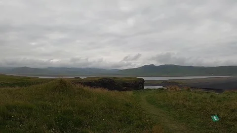 Looking down at Dyrholaey natural stone bridge and black sand coast, Iceland Stock Footage 334679710