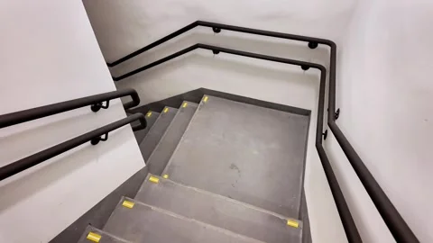 Looking Down Empty Concrete Staircase with Black Handrails Видео 343151502