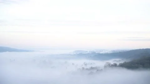 Looking down on evening fog in a valley Stock Footage 144681555