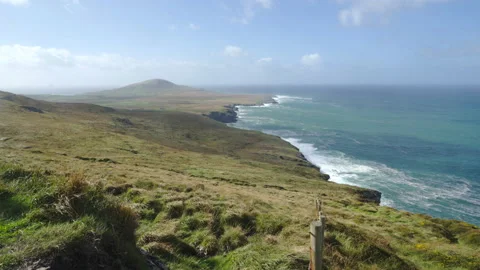 Looking down fence line to wave strewn coast of Valentia Island in Ireland Video stock 169974475