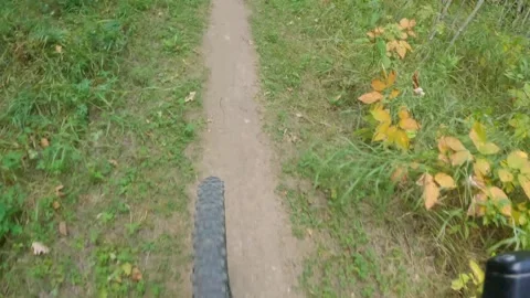 Looking down at the front wheel of a mountain bike as it is being ridden along a Stock Footage 273817005