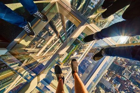 Looking down on glass floor elevator New York City with three pairs of tourist Stock-Fotos