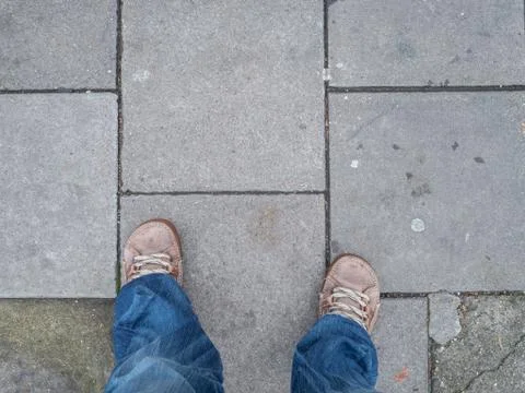 Looking down at grey concrete paving slabs Stock Photos