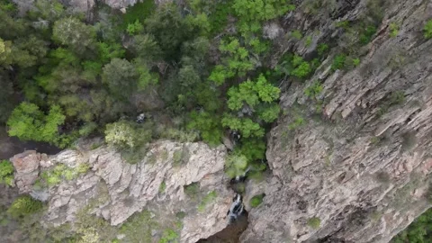 Looking down on a hidden waterfall in the rocky mountains Stock Footage 154223370