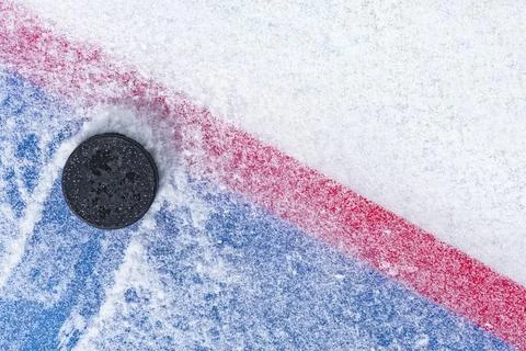 Looking down on a ice hockey puck sitting on the edge of the Goal Line of the Foto stock