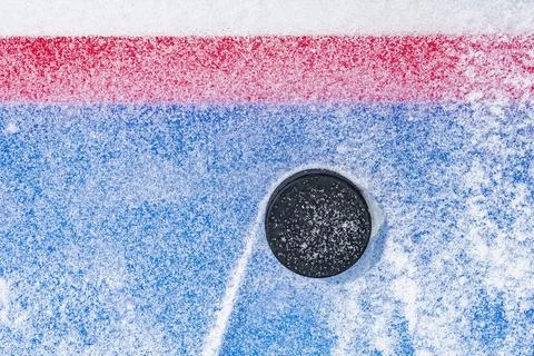 Looking down on a ice hockey puck sitting on the edge of the Goal Line of the Foto stock