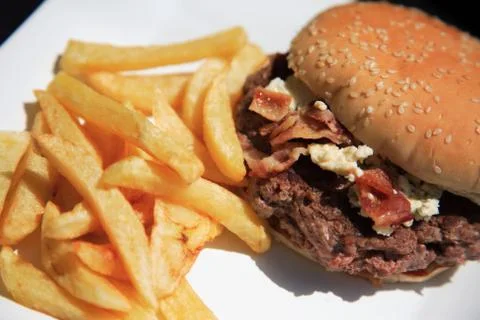 Looking down on a juicy beef burger and fries Stock Photos