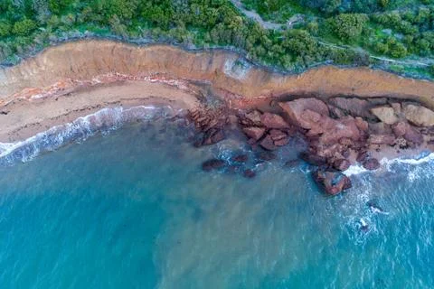 Looking down at large rocks and boulders on ocean beach - aerial view Stock Photos