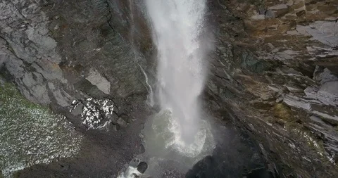 Looking down the length of massive waterfall splashing into canyon pool Stock Footage 111307374