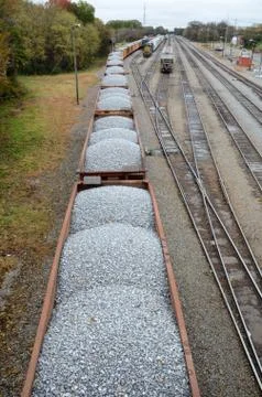 Looking down on a line of loaded rail cars loaded with gravel. Stock Photos