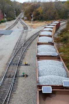 Looking down on a line of loaded rail cars loaded with gravel. Stock Photos