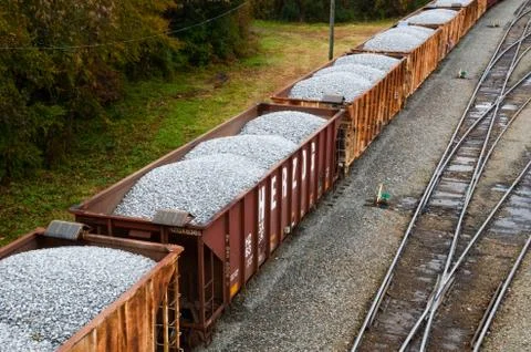 Looking down on a line of loaded rail cars loaded with gravel. Stock Photos