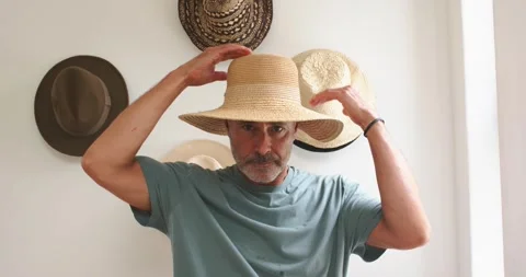Looking down, mature man lifting wide-brim straw hat, positioning and adjusting Video stock 340257602