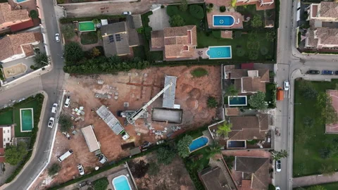 Looking down at modular home hanging from industrial crane on construction Vídeos de archivo 224337403
