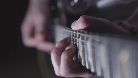 Looking down neck of electric guitar while man plays. Focus on frets, Video stock 240184770