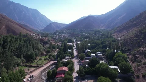 Looking down a North Road valley, a tree-lined street runs through a mountain Stock Footage 343805889