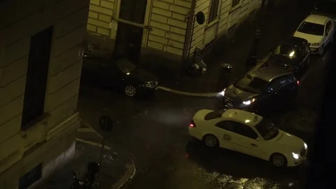 Looking down out of an apartment window showing rainy street crossing 4k Stock Footage 77446394