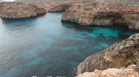 Looking down over at clear sea with rocky sides of island Video stock 37531805