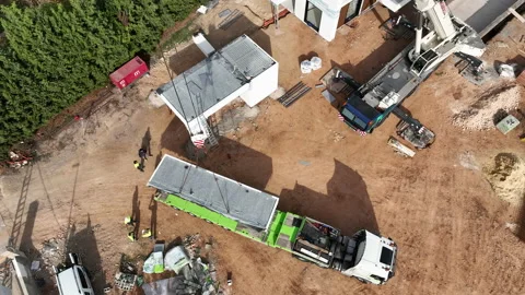 Looking down over crane unloading modular home delivery to construction Vídeos de archivo 224338196