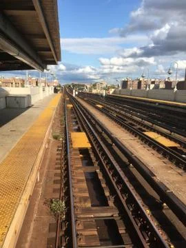 Looking down the overground subway tracks at an empty subway platform in Queens Stock Photos