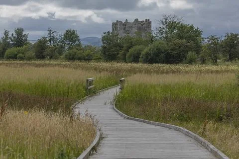 Looking down a pathway towards a derelict castle Foto stock