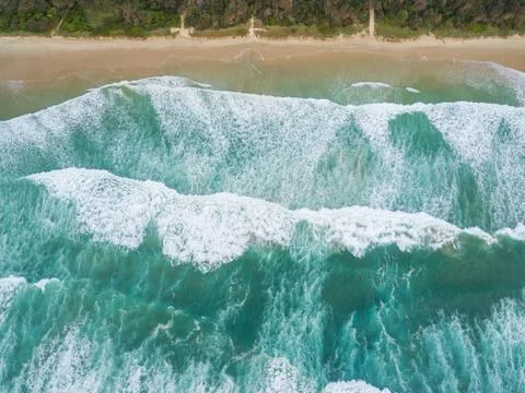 Looking down at powerful ocean waves and coastline Stock Photos