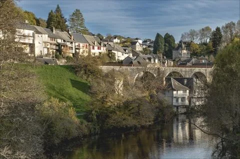 Looking down a river at two houses suspended partly across theriver Stock Photos
