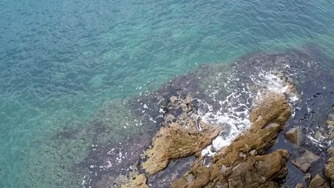 Looking down to rocks and the sea from the edge of a cliff Stock-Footage 89686683
